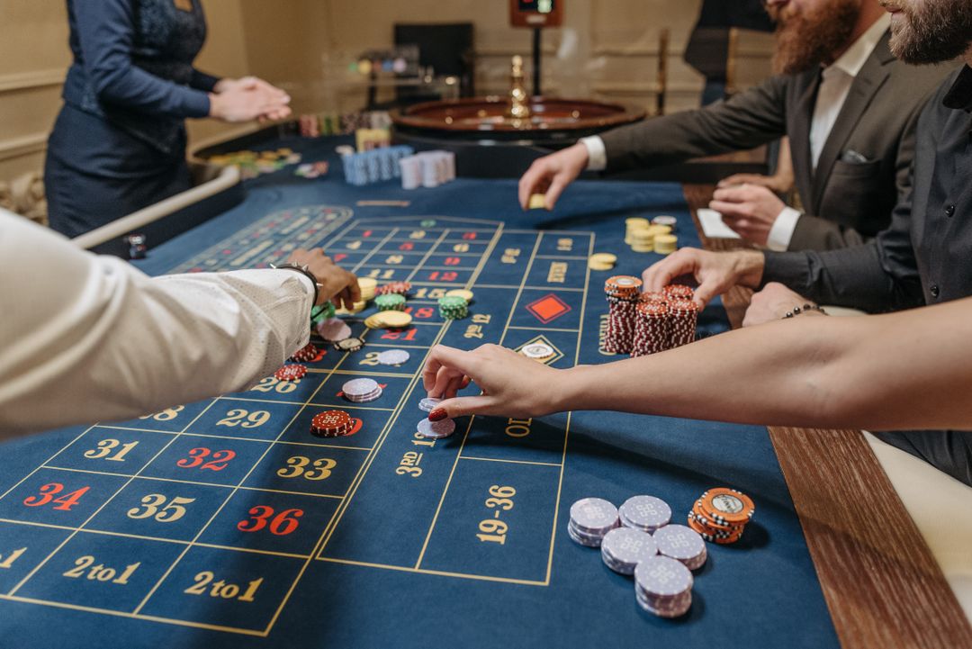 Meja roulette dengan chip dan pemain di kasino